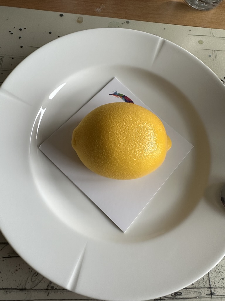 A cake shaped like a lemon, on a plate at home