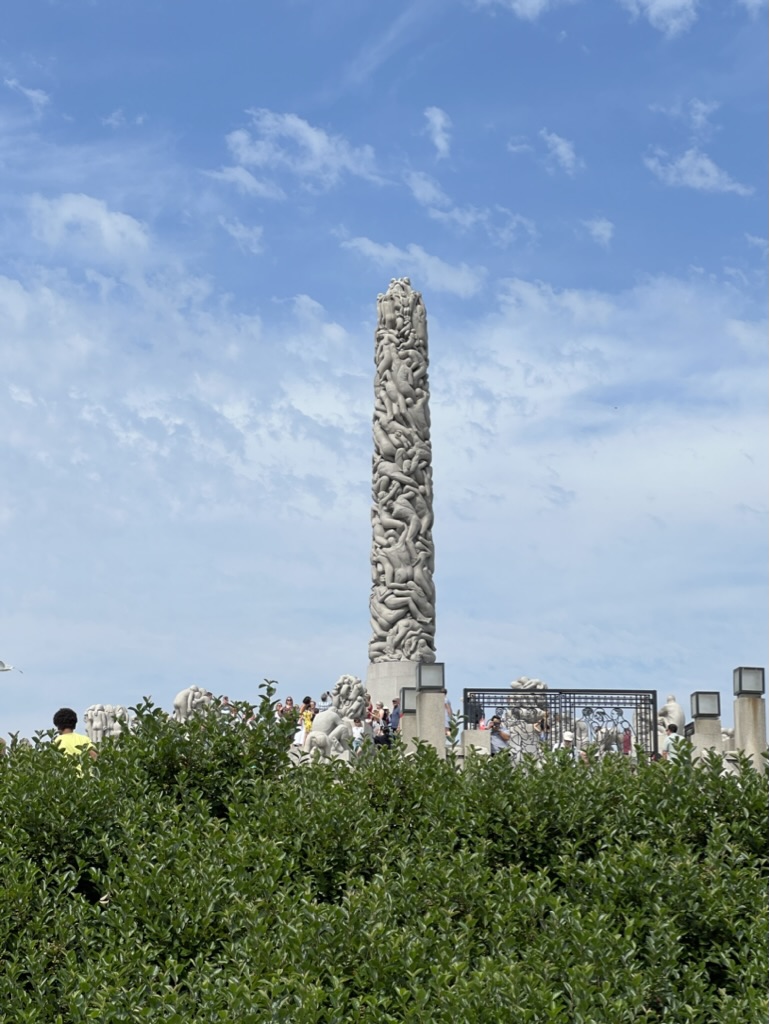 The Vigeland Monolith surrounded by visitors on a sunny day