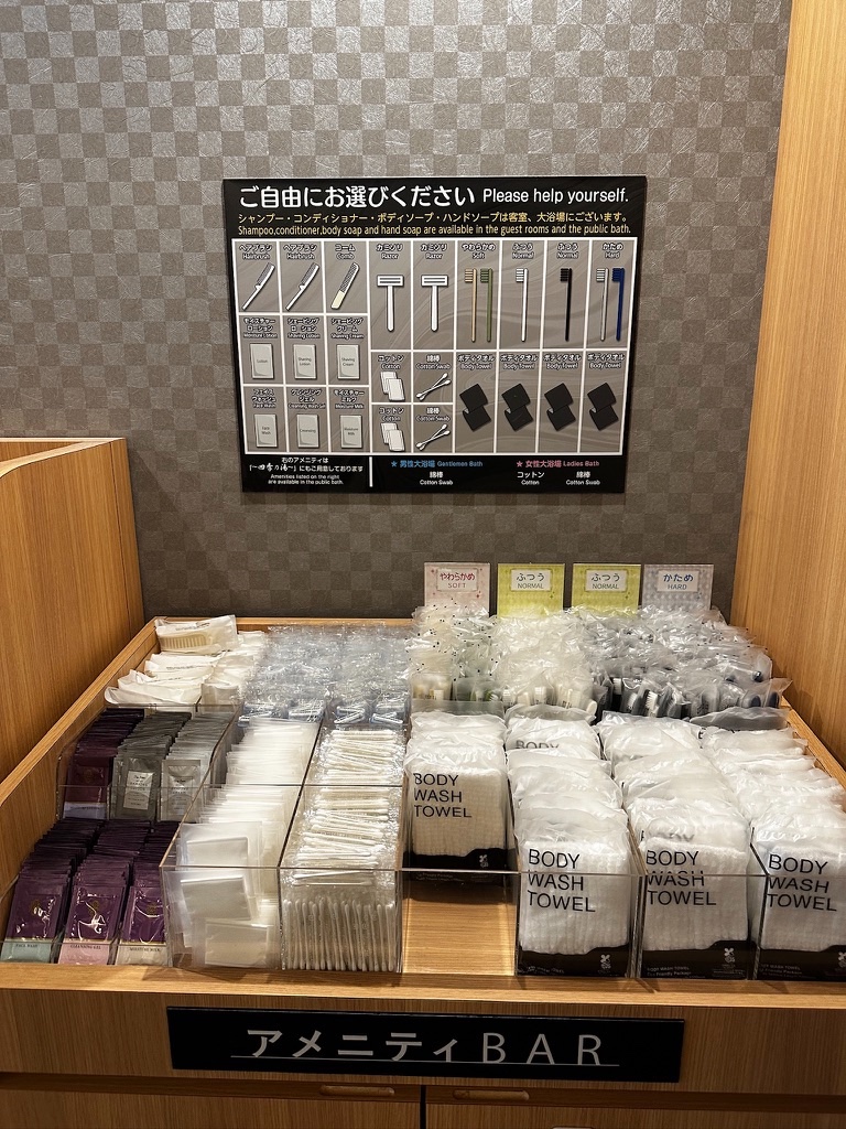A hotel amenity bar with rows of free toothbrushes, cotton pads and body wash towels to help yourself to