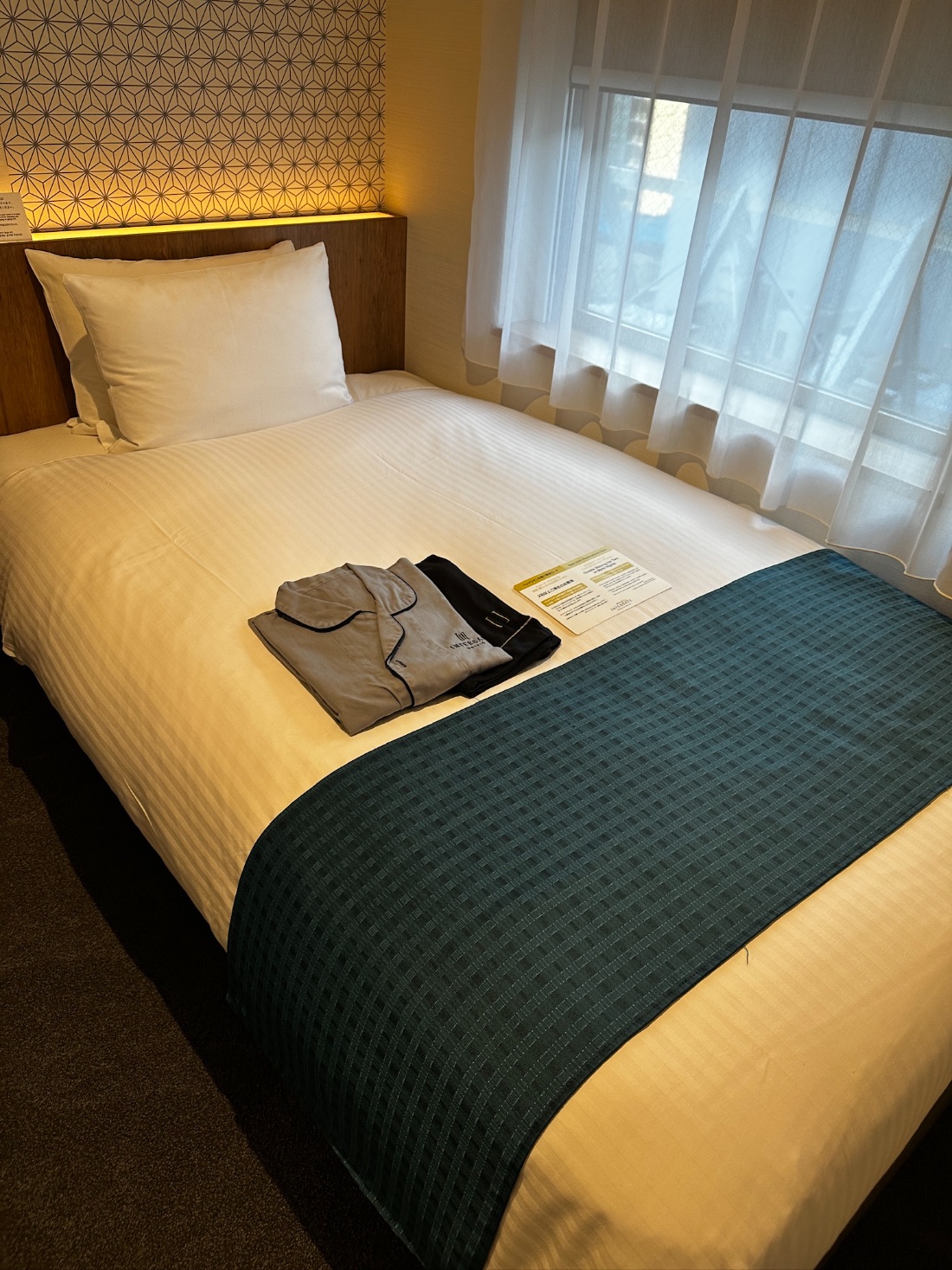 A Japanese hotel room with the provided sleepwear folded neatly on the bed